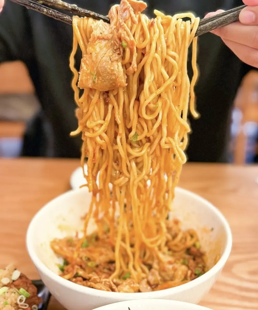 Chasu aburasoba noodles lifted with chopsticks at Kajiken-Fullerton, a Japanese Aburasoba Restaurant in Fullerton